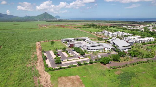 Ecole du nord, mauritius, surrounded by green fields under a clear sky, daylight, aerial view