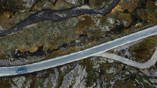 Aerial footage of blue van on small road in Norway.