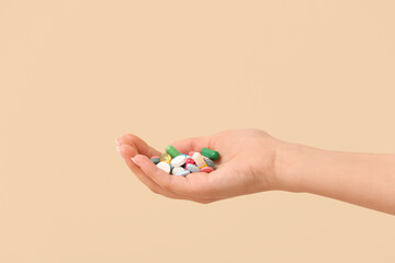 Woman holding different pills on yellow background