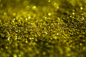 Abstract gold background of glowing lights in soft focus. Glitter golden backgrounds. Gold design....