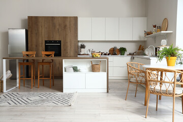 Interior of modern kitchen with white furniture and wooden island table