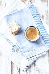 Coffee in glass cup on bright wooden background. Copy space.	