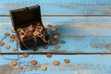 Old chest with treasures on blue wooden background © Pixel-Shot