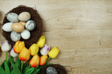 Obraz na płótnie Canvas Easter background with eggs and flowers bouquet top view on wooden background