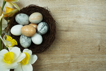 Fototapeta na wymiar Easter background with eggs and flowers bouquet top view on wooden background