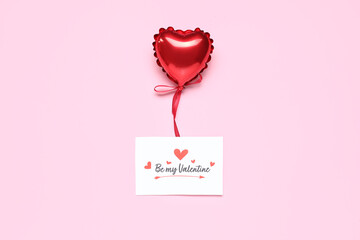 Greeting card with text BE MY VALENTINE and heart-shaped balloon on pink background