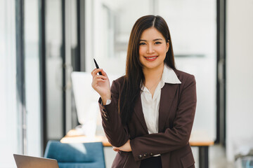Obraz premium Confident Asian businesswoman smiling at camera at modern office.