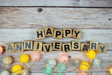 Happy Anniversary alphabet letters with LED cotton balls decoration on wooden background