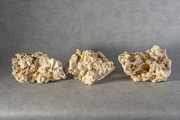 White texture stones with natural holes on a grey background. Design element.