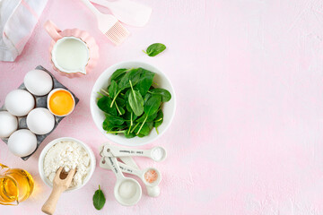 Obraz na płótnie Canvas Baking ingredients and kitchen utensils on a pink background, top view