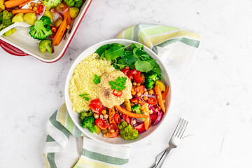 Baked vegetables with hummus bowl. Salad with baked potato, zucchini, broccoli and hummus.