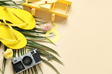 Composition with flip-flops, photo camera and palm leaf on color background. International Women's Day