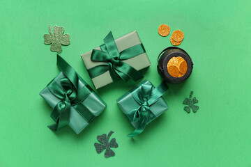 Gift boxes with pot of golden coins and clovers for St. Patrick's Day celebration on green...