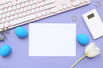 Easter eggs, flower, paper and computer keyboard on lilac background