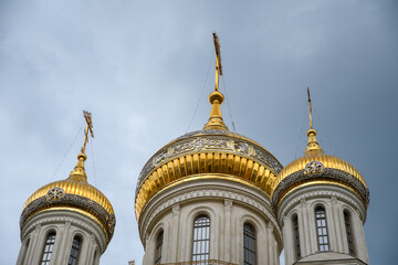 Fototapeta na wymiar Golden domes of an Orthodox church on a sunny Easter day against the blue sky.