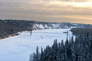 Fototapeta na wymiar View to Fort Edmonton footbridge in winter season with redish sky