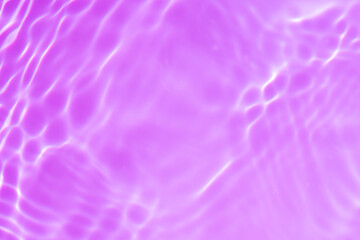 Water surface. Purple water waves on the surface ripples blurred. Transparent pink colored clear calm water surface texture with splash and bubbles. Purple water waves with shining patterns. Caustics.