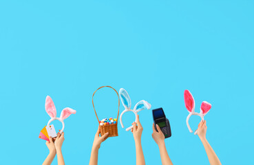 Women with bunny ears, Easter eggs and payment terminal on blue background. Online shopping