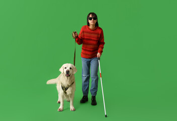 Blind woman with guide dog on green background