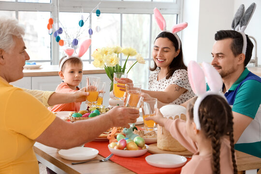 Happy family with juice having Easter dinner at home