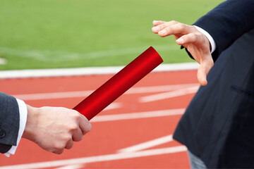 Businessman passing red baton to partner concept succession support teamwork 