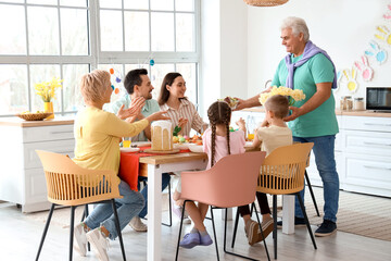 Mature man bringing salad for Easter dinner with his family in kitchen