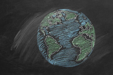 The globe hand drawn in chalk on a school blackboard.