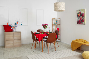 Modern interior of festive decorated dining room with Easter dining table, chest of drawers and chairs
