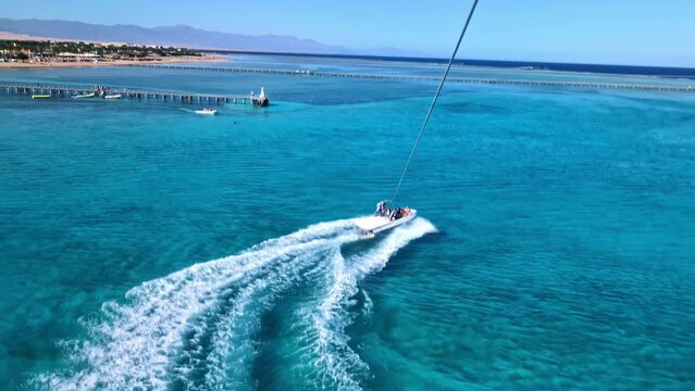 The view from a parasailer to the speedboat on the azure water of the Red Sea.