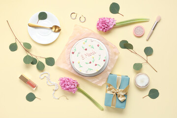 Sweet bento cake with beautiful flowers, jewelry and decorative cosmetics on yellow background. International Women's Day