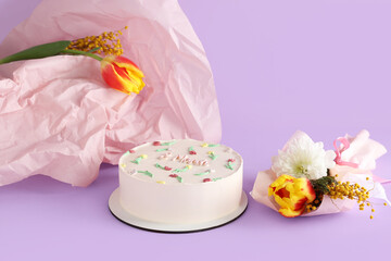 Sweet bento cake and beautiful flowers on lilac background. International Women's Day