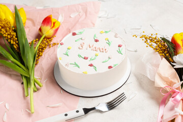 Sweet bento cake and beautiful flowers on white background. International Women's Day