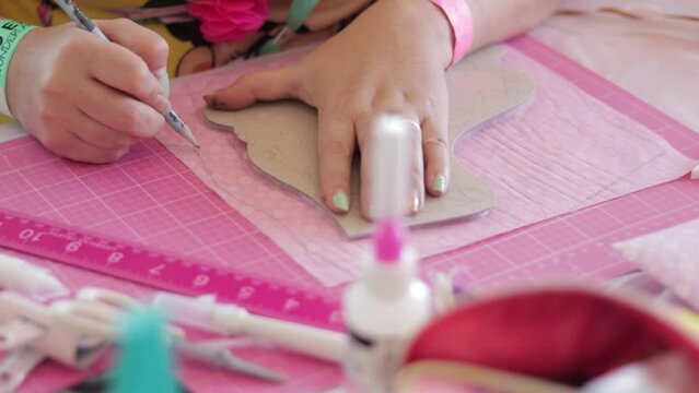 Woman in a craft workshop making sketches on pink paper