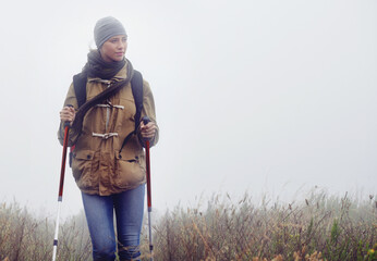 Woman, hiking and nature with trekking sticks, winter and support for fog trail in mountain....