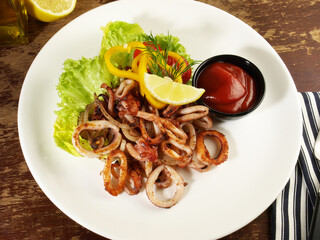Octopus, Fried Calamari Rings with Salad on a Plate with Chili Sauce and Lemon - 748543136
