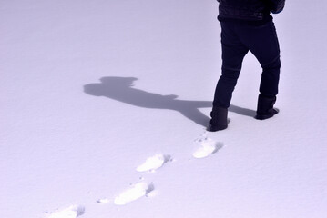 雪の上を歩く男性の足元