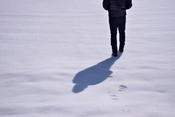 雪の上を歩く男性の足元