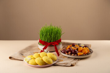 Beautiful Novruz setting on peachy neutral background with fresh semeni wheat glass with red...