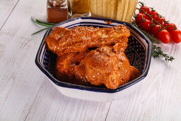 Raw turkey shoulder wing in Indian tandoori marinade