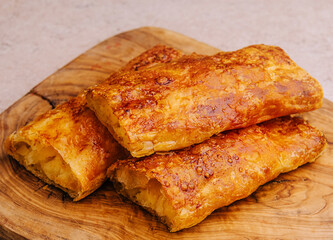 Baking puff pastry with potatoes on wood board