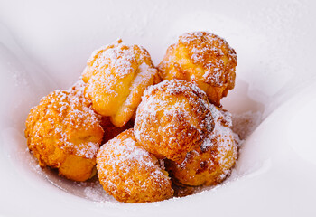 Profiteroles with powdered sugar close up