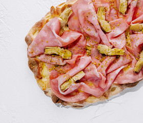 square pizza with ham and artichokes top view