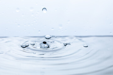 An image capturing the mesmerizing moment of a water droplet creating a splash upon hitting...
