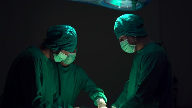 Team of surgical doctor performing a surgery in operating room.
