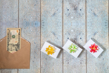 Giftboxes with ribbons a wooden table. Wooden background with copyspace and money