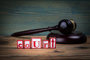COURT Concept. Red alphabet letters and judge's gavel on wooden background. Laws and justice concept