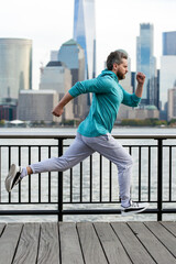 Run. Healthy Man running in New York City. Fitness sport, man runner is jogging near Manhattan. Man running on American street. Man running in New York in sport clothes. Sport wear for mature runners.