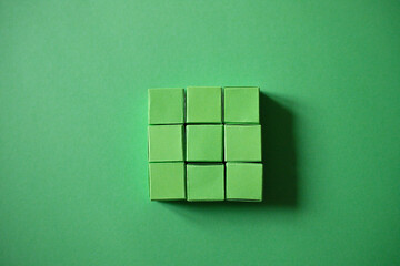Arranged Green Cubes Casting Shadows on Green Teal Surface - Abstract Design Representing Eco-Friendly Development