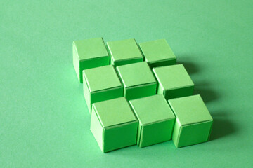 Arranged Green Cubes Casting Shadows on Green Teal Surface - Abstract Design Representing Eco-Friendly Development