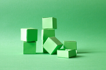 Arranged Green Cubes Casting Shadows on Green Teal Surface - Abstract Design Representing...